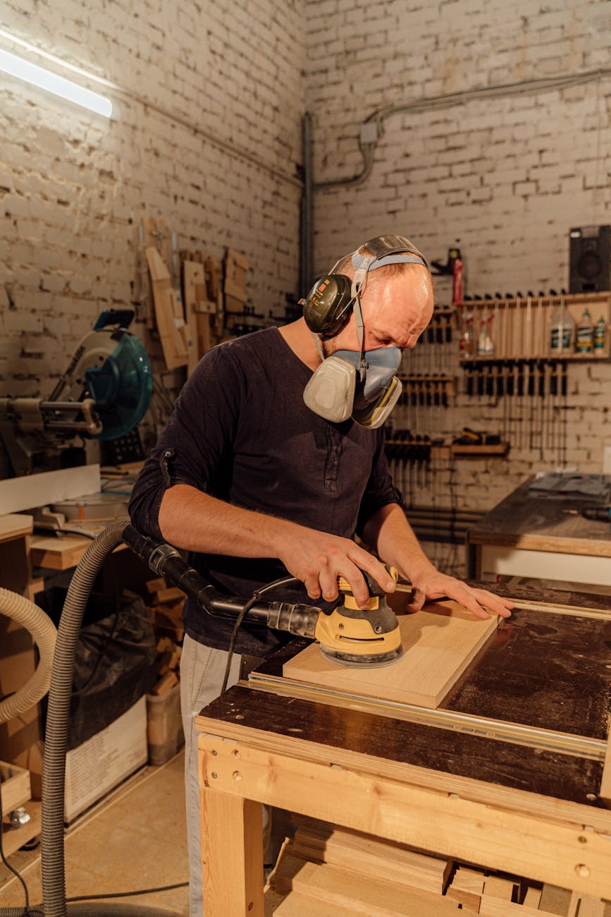 a man sanding a wood plank